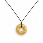 Handmade gold sea urchin pendant necklace on black cord inspired by Mediterranean marine life.