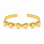 a triple bow gold cuff bracelet on white background